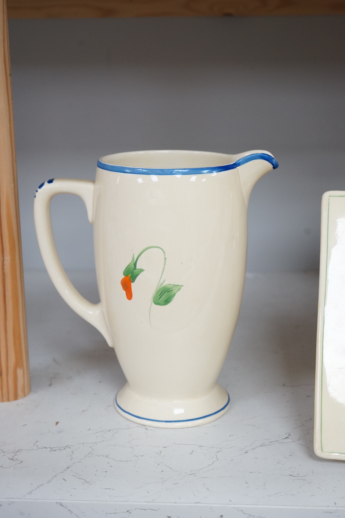 Three Clarice Cliff Bizarre ‘Biarritz’ dishes and a Wilkinson floral jug, largest 23cm wide